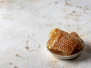 Honey in honeycombs in a saucer , text space