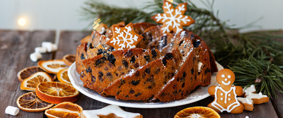 Traditional christmas sweet food: homemade cake with raisins, nuts, fruits decorated with...