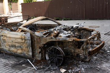 arson for revenge. burnt car parked on the street, close-up.