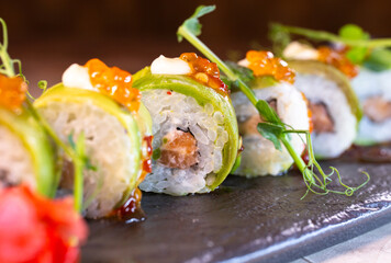Japanese rolls with avocado on black dishes