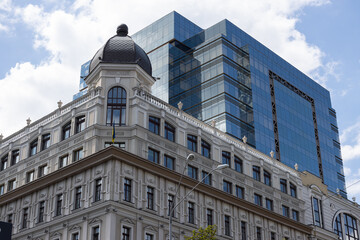 Fototapeta premium Glass business building. Reflection of the sky on a business building. Bottom view of modern skyscrapers