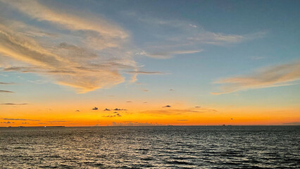 Sunset by the ocean on a calm cloudy day