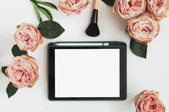 Creative workplace layout with blank screen tablet, flowers, business card. Female workspace mockup