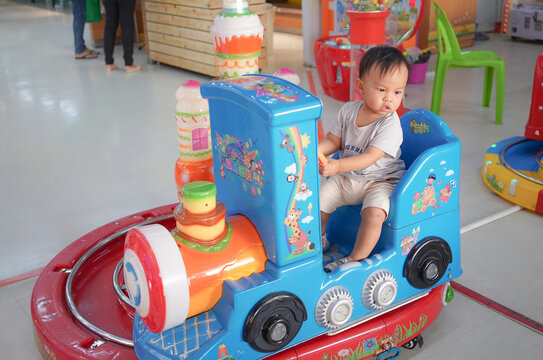 Roiet, Thailand - Feb 14 2022 : Asian Toddler Boy driving Toy Car, Train and Having Fun