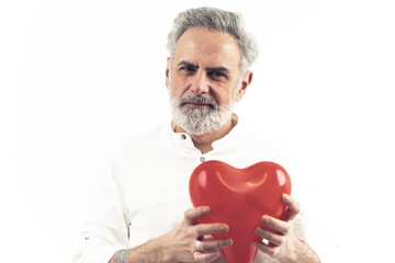 grey haired Caucasian man shows heart shaped balloon, holding it by heart isolated white background copy space . High quality photo