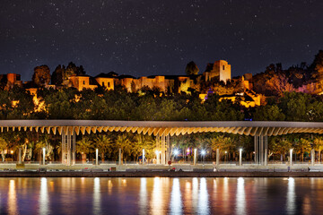 Malaga Hafen mit Blick &uuml;ber die Promenade auf die Alcazaba bei Nacht