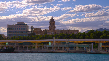 Blick auf die Hafen Promenade Muelle Uno und Kathedrale von Malaga bei blauem Himmel 