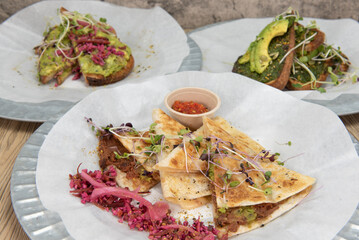 Full table of organic food choices with the jerk jackfruit quesadilla up in front