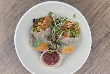 Vegetarian style spring roll, cut in half to show super green ingredients and a healthy dipping sauce for that nutrition conscious diet