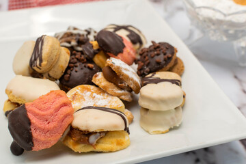 breakfast or snack with a cup of tea fine doughs of cornstarch chocolate vanilla and dulce de leche on a marble table with sugar bowl and decorative candle