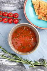 Tomato soup, tomato soup on a white wooden background, top view