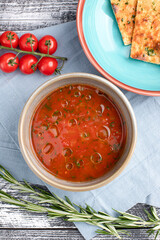 Tomato soup, tomato soup on a white wooden background, top view