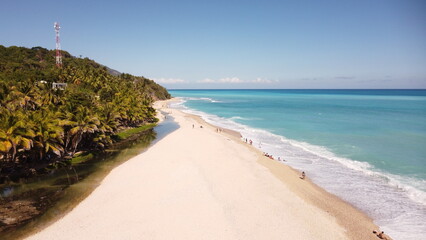 Hermosa Playa con agua turquesa y azul profundo arena blancay cocotales hermososcon un cielo azul...