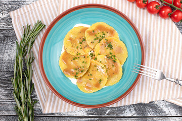 ravioli, italian ravioli on a white wooden background, top view