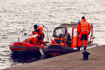 Water lifeguards on the pier. Motor boats with rescuers moored to the shore. Rescue inflatable...