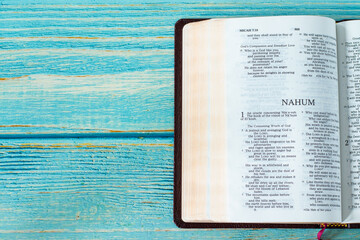 Nahum open Holy Bible Book on a rustic wooden background with copy space. Top table view. Old...