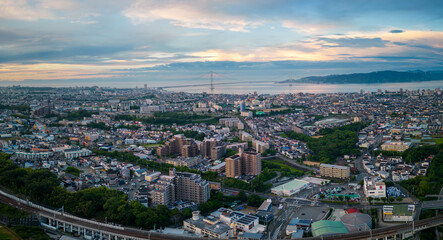 Panoramic sunrise view of sprawling Akashi city and suspension bridge to Awaji Island 