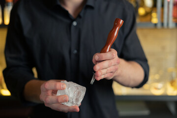 bartender prepares a cocktail in a bar, club. pours alcohol and syrups. uses ice and breaks ice