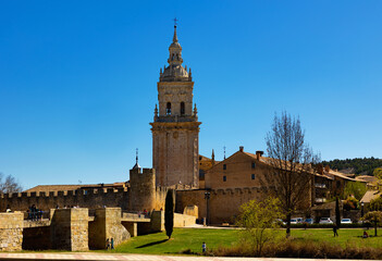 Fototapeta na wymiar Scenic spring landscape with view of medieval Roman Catholic Cathedral of Assumption of El Burgo de Osma on bank of river Ucero, Spain.