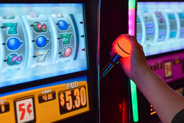 Female hand arm playing slot machine at casino