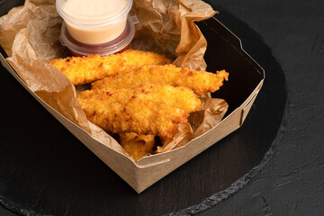 Grilled cheese, cheese sticks on a black background, side view