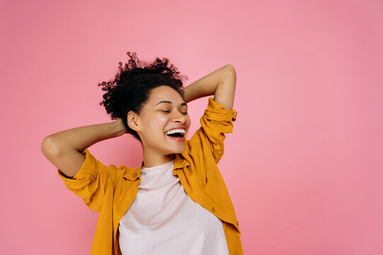 Joy, victory, luck, dancing. Cheerful happy african american girl in casual wear,dancing to favorite music, having fun, rejoice in luck, celebrating win, on isolated pink background, smiling
