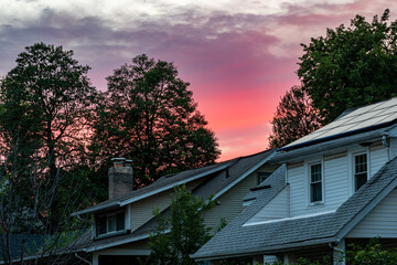 Colorful sunset sky behind suburban Washington, DC rooftops.