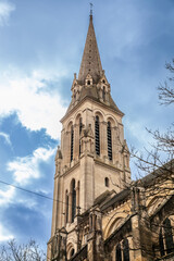 Fototapeta na wymiar Steeple tower of the Eglise Notre Dame de bergerac church, the main catholic church, neogothic, built in the 19th century in Bergerac, a city of Dordogne, in Perigord, in France...
