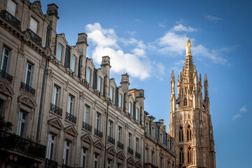Fototapeta na wymiar Tour Pey Berland tower seen from an old bordeaux street with residential buildings. Pey Berland Tower is the steeple bell tower of the Cathedrale Saint Andre Cathedral in Bordeaux, France...