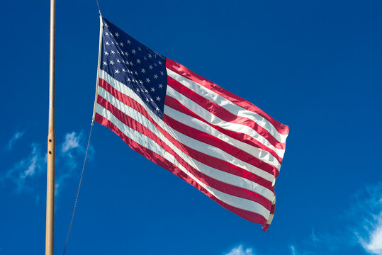 American flag waving in the wind against a blue sky.