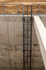 The steel stair on the concrete wall of the well. High quality photo