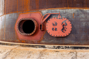 Opened rusty manhole on the fuel tank shell storage tank. High quality photo