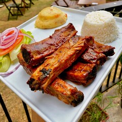 pork ribs served with rice porê, potato and salad in the restaurant of barbecue