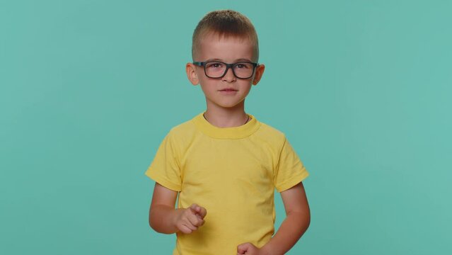 Quarrel. Displeased little toddler children boy shakes finger and saying no, be careful, scolding and giving advice to avoid danger mistake, disapproval sign. Young preschool kid on blue background