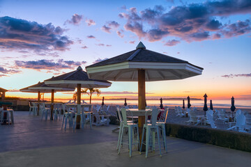 Tables and umbrellas on the ocean at dawn in the early morning.. Resting-place. USA. Maine.
