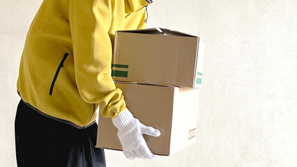 段ボール箱2つを抱える軍手をした人_横ワイド