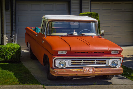 Retro pickup truck on a sunny summer day. Orange Chevrolet C10 Pick Up Truck. Vintage Chevy truck parked on a street