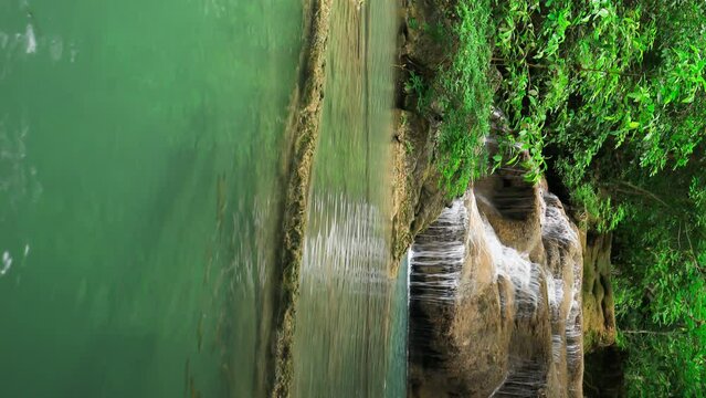 vertical Time-lapse of Level 1 of Erawan Waterfall with Neolissochilus stracheyi fish in Kanchanaburi Province, Thailand