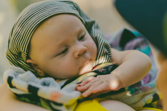 Cute 2 month old baby looking at his mother close up portrait. Summer vacation with newborn or infant baby.