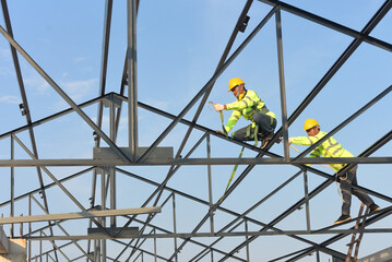 Construction workers wear safety harnesses and safety lines working at high places construction...