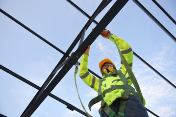Construction workers wear safety harnesses and safety lines working at high places construction...