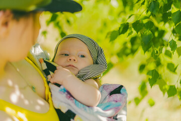 Cute 2 month old baby close up portrait. Summer vacation with newborn or infant baby. Mother holding her child.