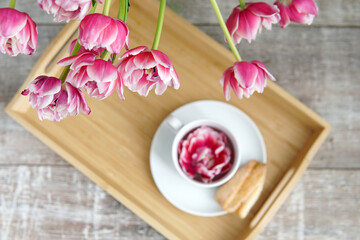 Breakfast with tulips. A cup of coffee with a flower.