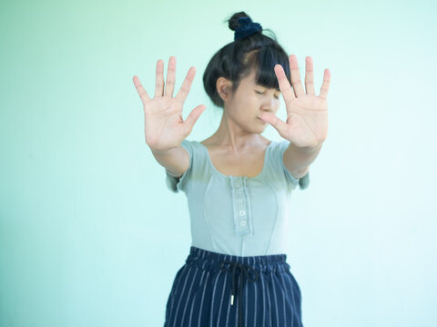 Portrait Alone Woman Showing Finger No Symbols On Wall Green Cement Background. Authentic Skin Tan And Black Hair Asian Woman And Slim Fit. She Show Hand Stop And Sad Stress Face.do Not Need Concept.