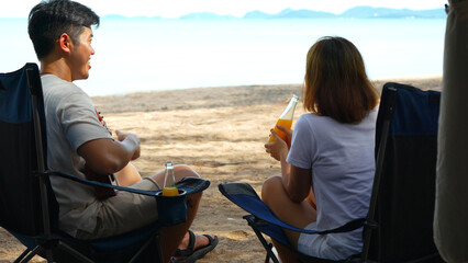 Asian couple enjoying together camping on ther beach male playing ukulele having fun and freedom on summer vacation people lifestyle activity on weekend concept.