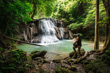 Thai guy Asian man backpacker men enjoying beautiful emerald waterfalls green forest mountains...