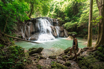 Thai guy Asian man backpacker men enjoying beautiful emerald waterfalls green forest mountains guiding for Thailand destinations camping hiking at Huai Mae Khamin waterfall national park, Kanchanaburi