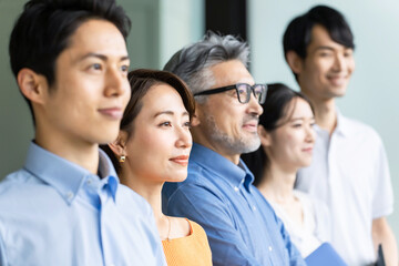 遠くを見つめるクールビズのビジネスグループ