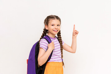 A child with a school backpack points up at your advertisement on a white isolated background. A...