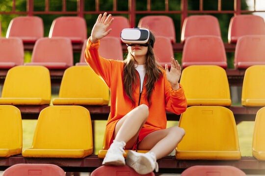A young athlete wearing virtual reality glasses, dressed in sportswear, trains with a virtual simulated world. Technology of the future